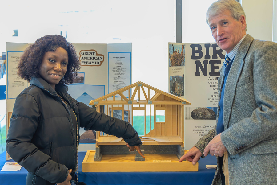 two people in front of model house structure